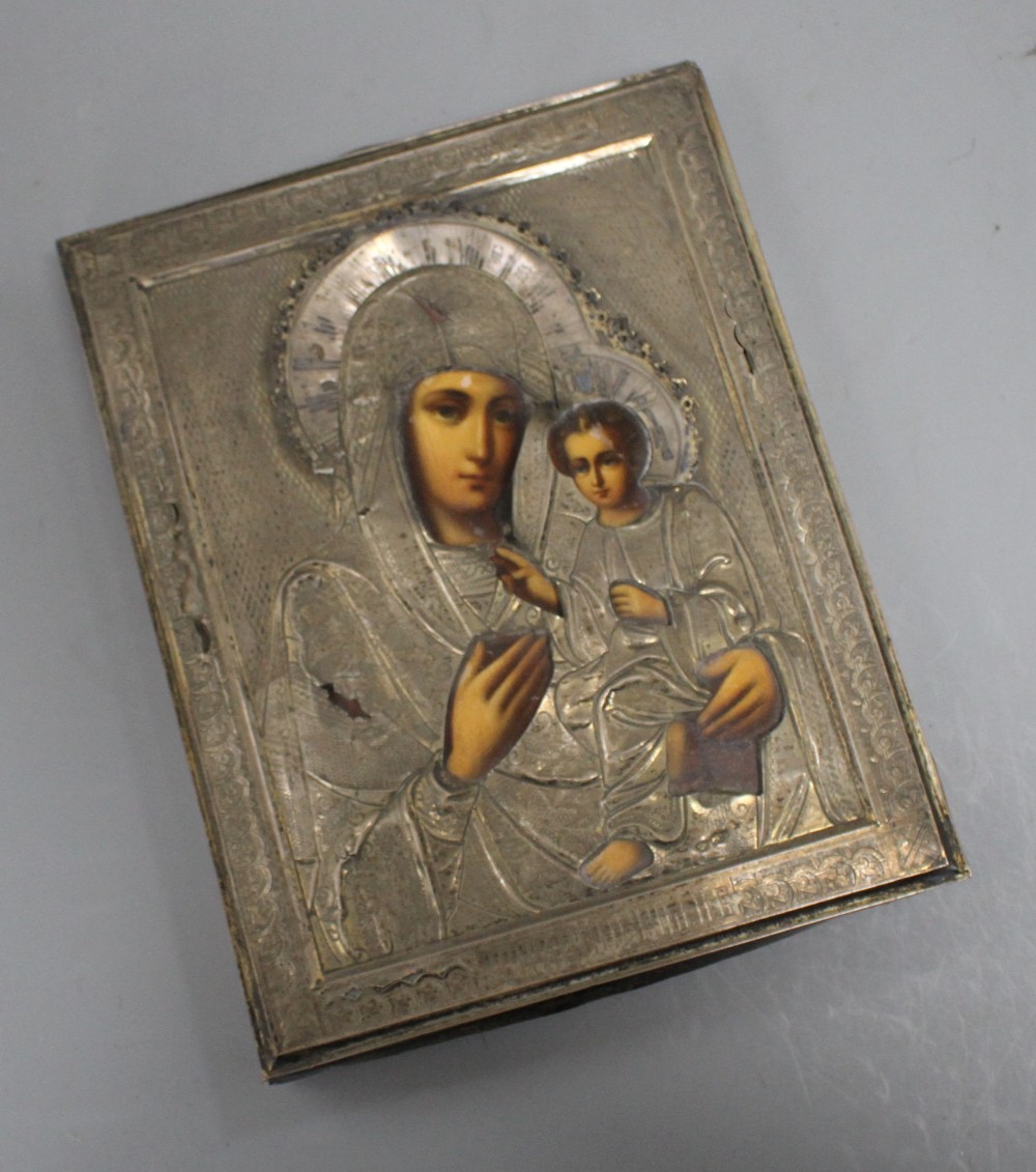 A Russian white metal overlaid tempera on panel icon, depicting the Virgin Mary and Christ child, 22 x 18cm